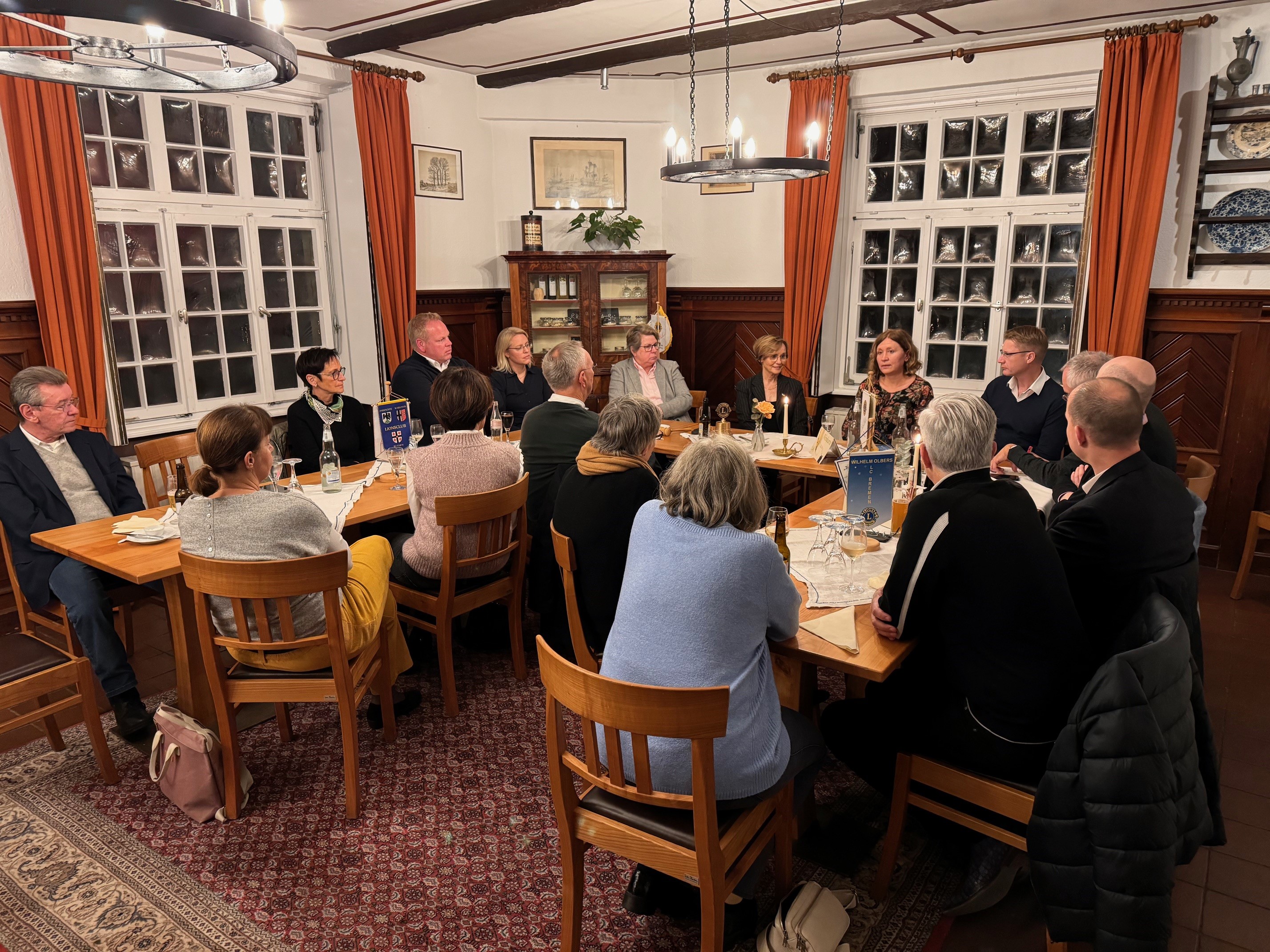 Clubmitglieder und 2 Besucher am Tisch versammelt